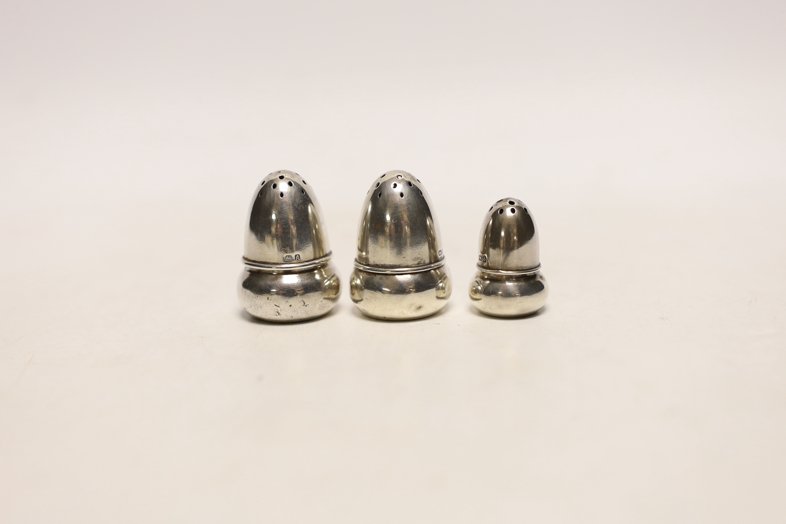 Two pairs of small Edwardian silver acorn pepperettes, the largest, Birmingham, 1903, 36mm and one other silver acorn pepperette.